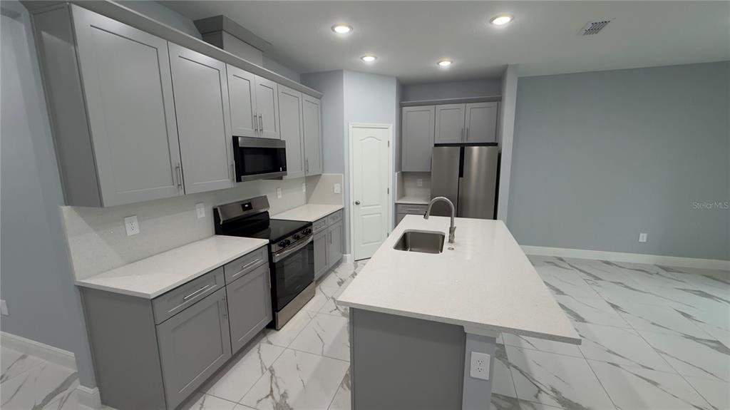 706 South Thacker Avenue Kissimmee, FL 34741 - Photo 19 of 36 a kitchen with a sink a stove and refrigerator