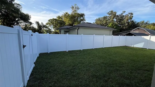 a view of a backyard with potted plants and wooden fence