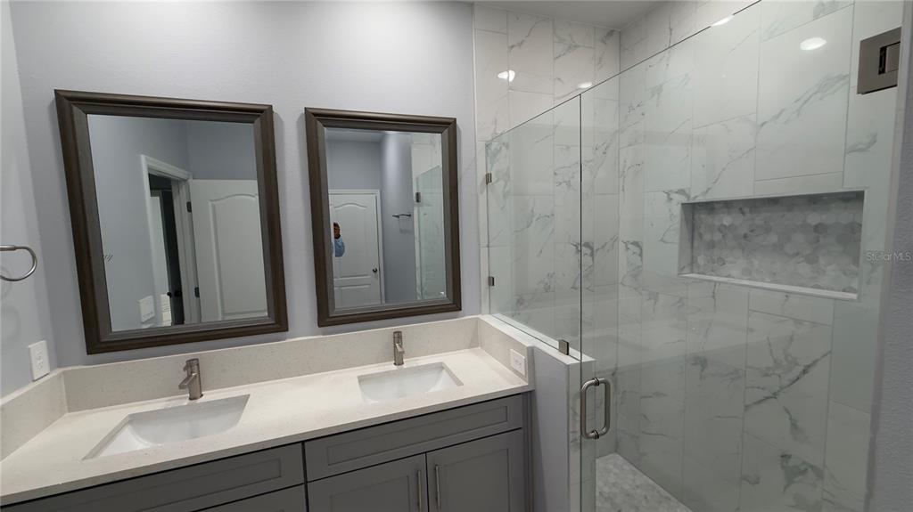 706 South Thacker Avenue Kissimmee, FL 34741 - Photo 31 of 36 a bathroom with a shower sink and mirror