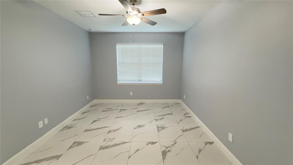 706 South Thacker Avenue Kissimmee, FL 34741 - Photo 34 of 36 an empty room with a window and a fan