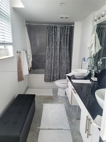 a bathroom with a granite countertop sink a toilet and bathtub