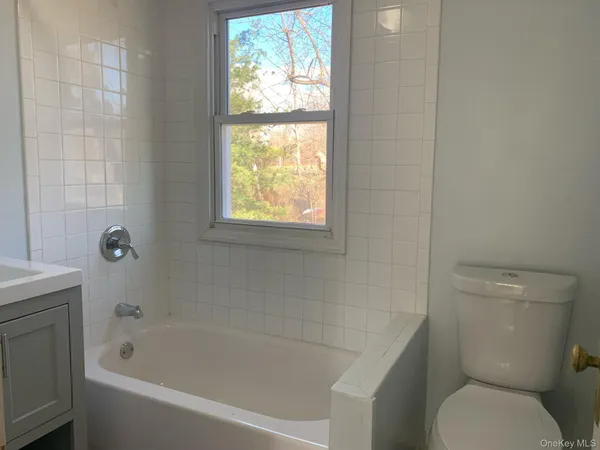 a white toilet sitting next to a bath tub