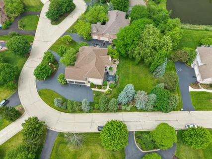 an aerial view of a house with a garden and lake view