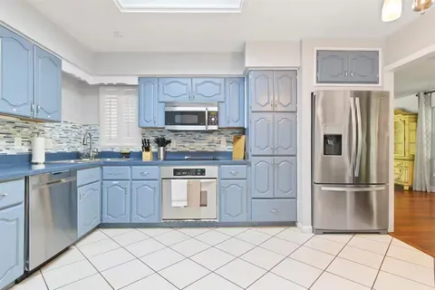 a kitchen with granite countertop a refrigerator and a stove top oven