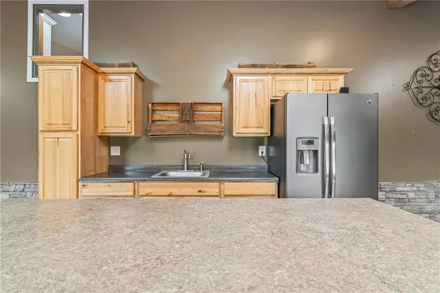 a view of a refrigerator in kitchen and a window