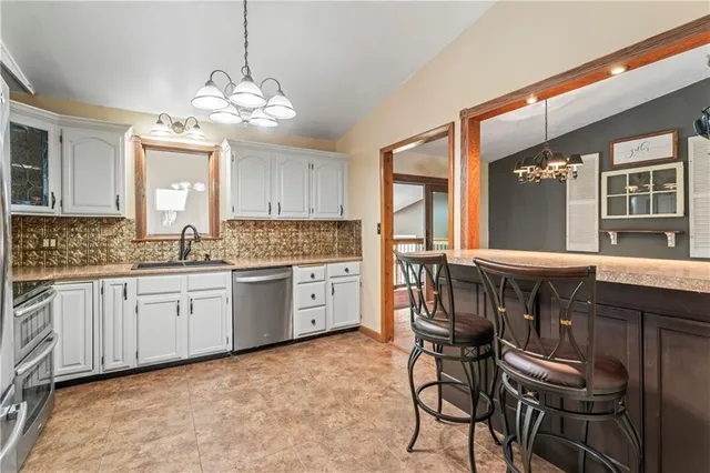 a kitchen with a dining table chairs cabinets and stainless steel appliances