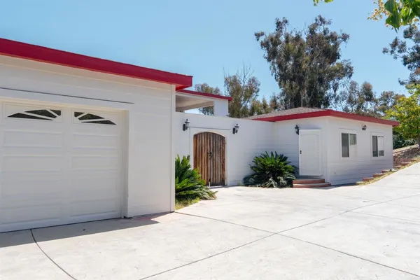 a view of an empty room with wooden floor and a fireplace