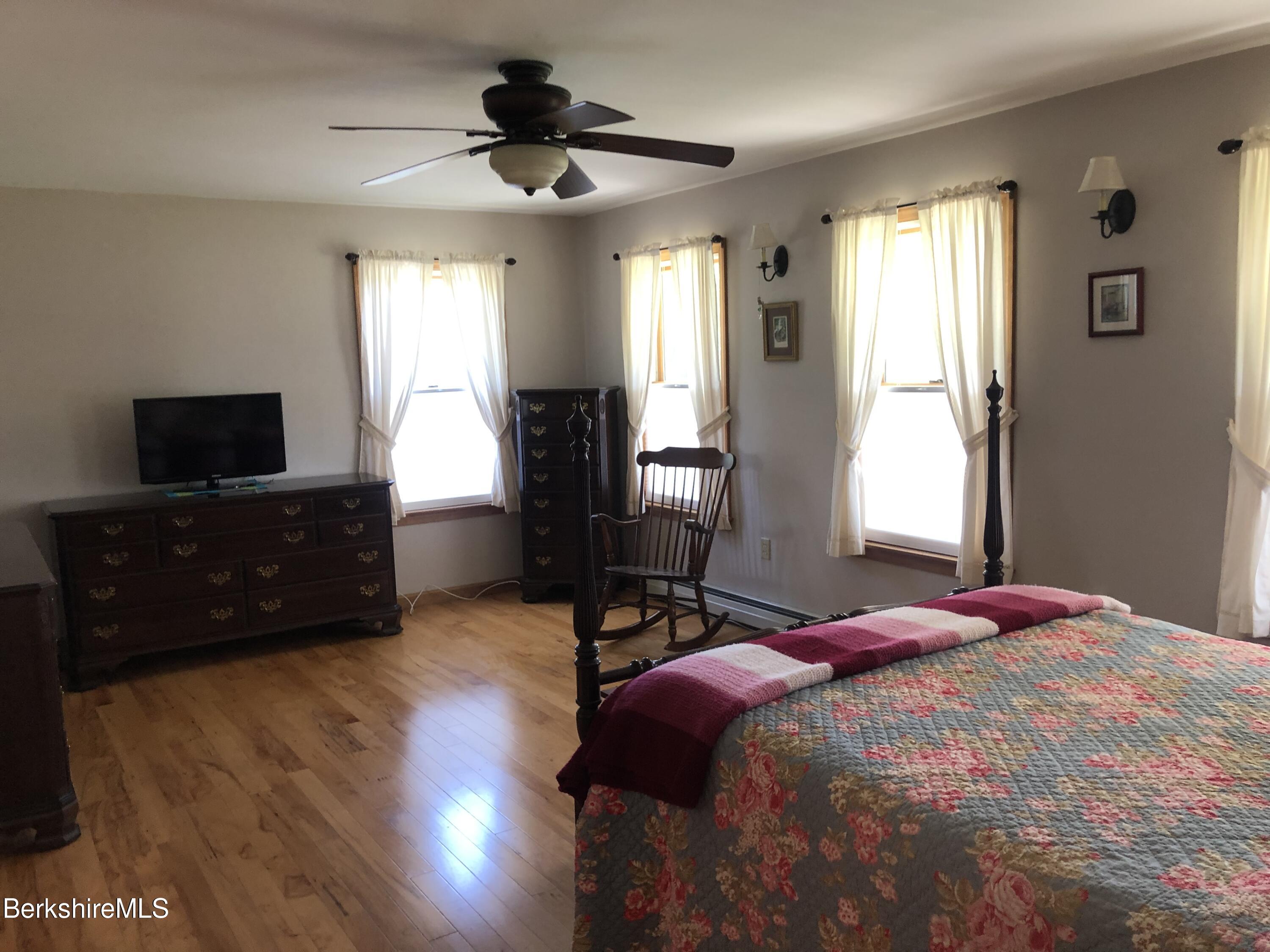 1387 East Windsor Road Windsor, MA 01270 - Photo 19 of 38 a bedroom with a bed windows and a flat screen tv