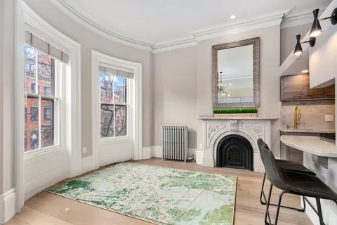 a view of livingroom with furniture a fireplace and windows