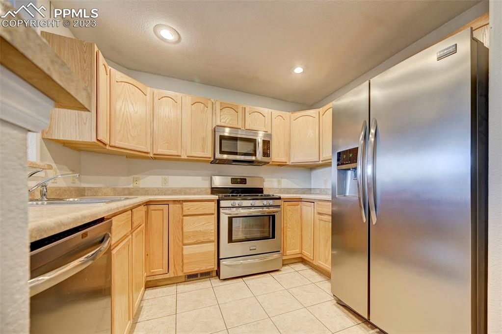 5433 Prominence Point Colorado Springs, CO 80923 - Photo 11 of 26 a kitchen with cabinets stainless steel appliances and a counter top space