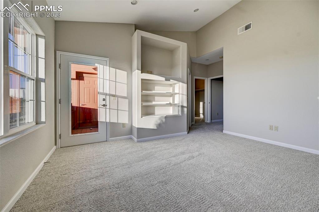 5433 Prominence Point Colorado Springs, CO 80923 - Photo 21 of 26 a view of an empty room with a fireplace and windows