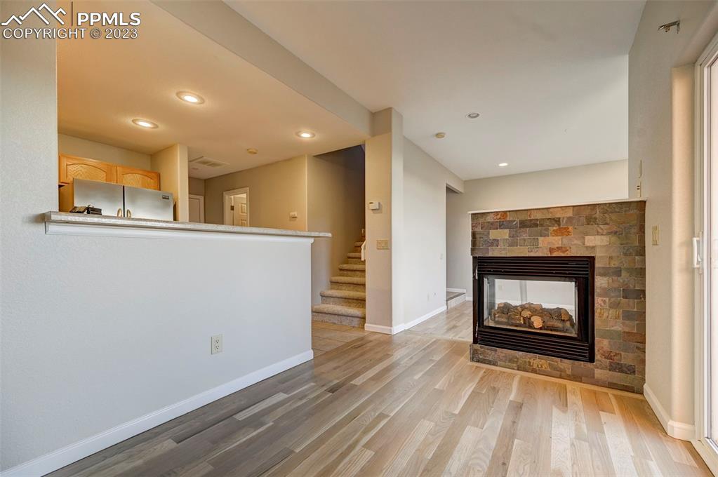 5433 Prominence Point Colorado Springs, CO 80923 - Photo 9 of 26 a view of an empty room with wooden floor fireplace and a window