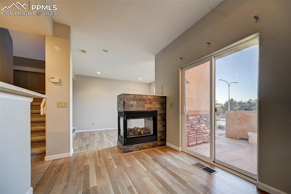 5433 Prominence Point Colorado Springs, CO 80923 - Photo 10 of 26 a view of an empty room with wooden floor fireplace and a window