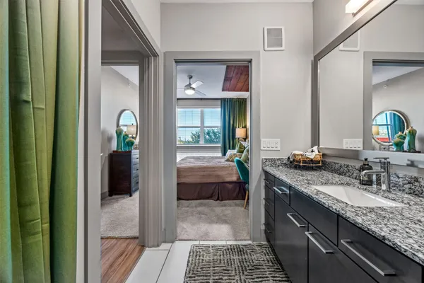 a bathroom with a granite countertop sink a toilet and a mirror