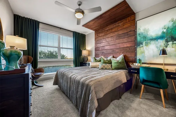 a bedroom with a bed chair and a large window