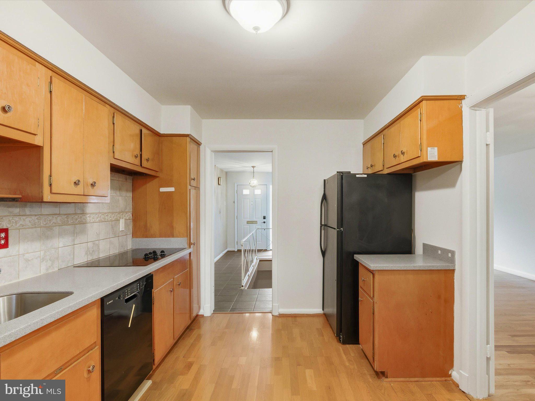 1454 Roxanna Road Northwest Washington, DC 20012 - Photo 14 of 48 a kitchen with stainless steel appliances granite countertop a refrigerator a stove and a sink with wooden floor