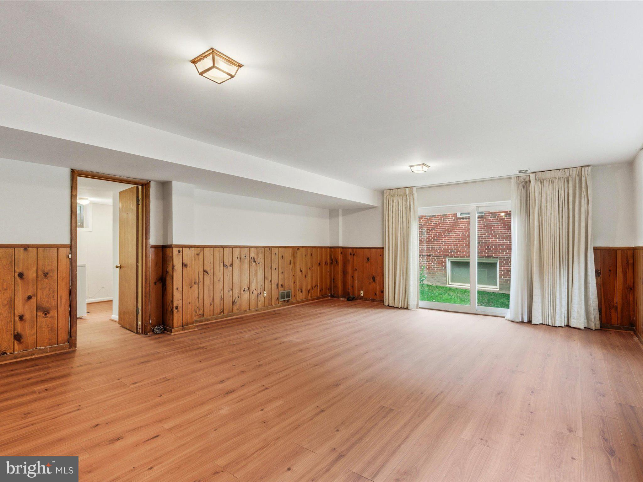 1454 Roxanna Road Northwest Washington, DC 20012 - Photo 29 of 48 an empty room with wooden floor and windows