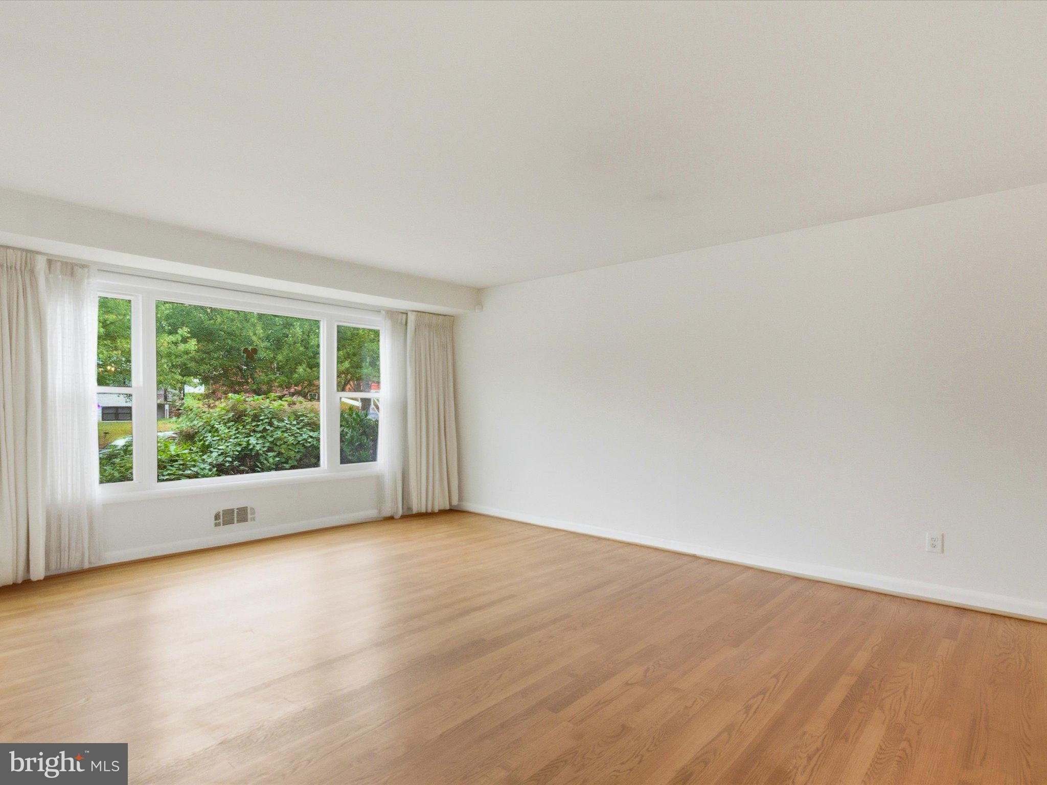 1454 Roxanna Road Northwest Washington, DC 20012 - Photo 7 of 48 a view of an empty room with wooden floor and a window
