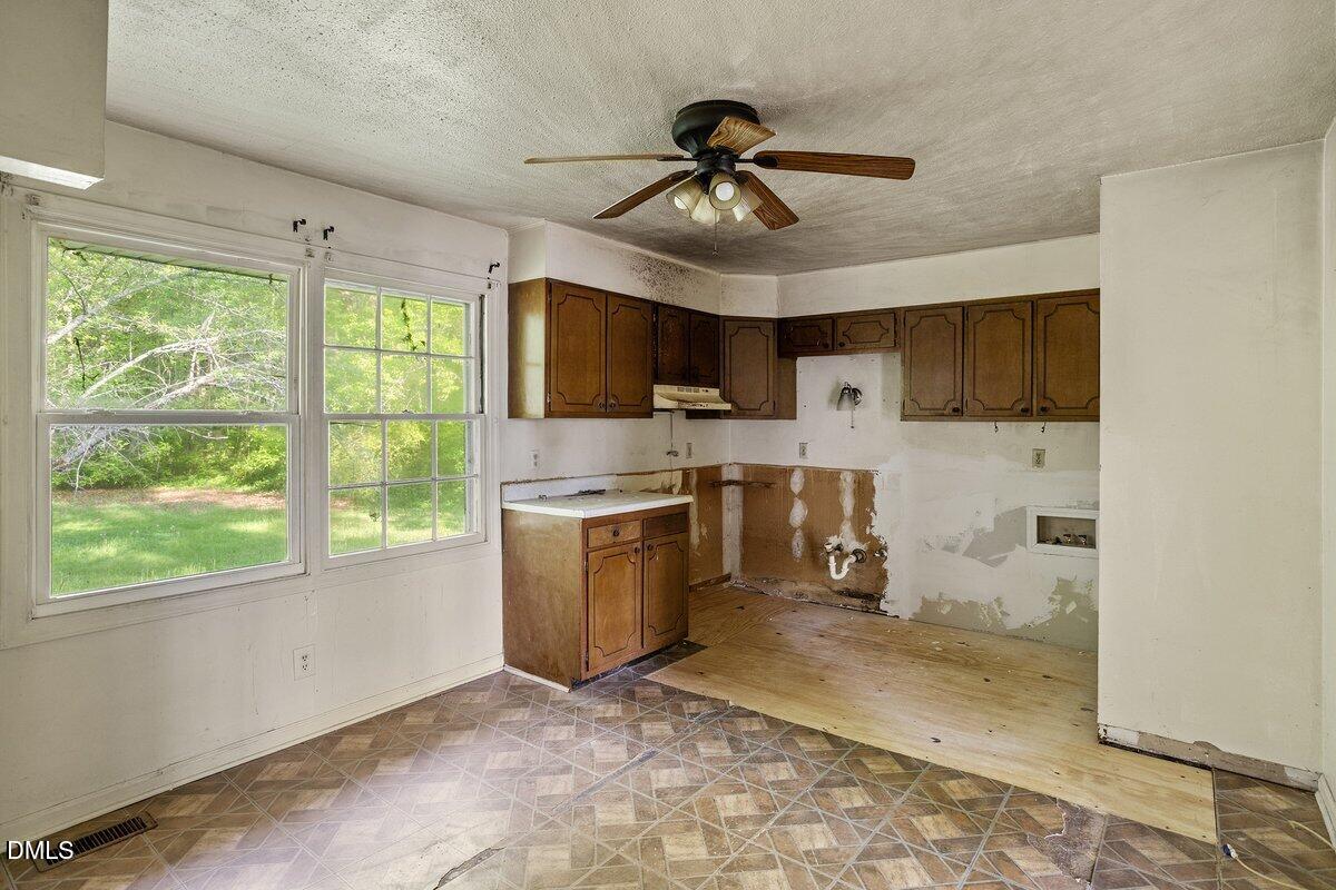 122 Richmond Road Mebane, NC 27302 - Photo 10 of 17 a kitchen with a refrigerator a stove top oven a sink a window and cabinets