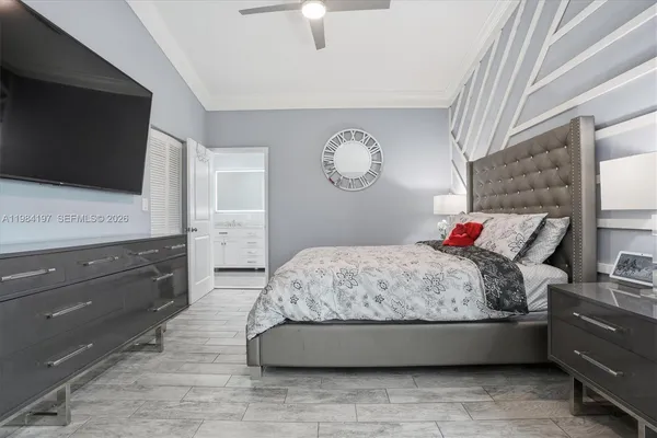 a spacious bedroom with a bed and a flat screen tv