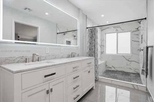 a bathroom with a granite countertop sink mirror and double