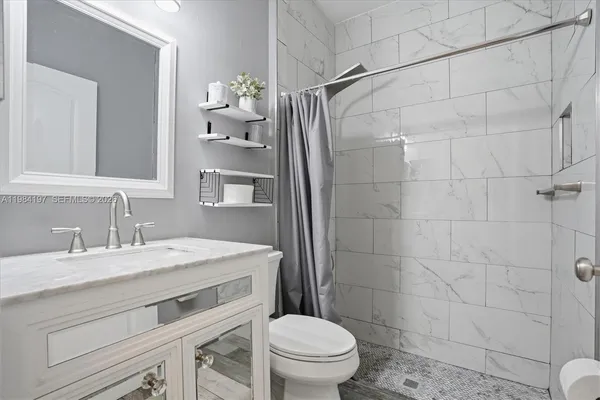 a bathroom with a sink toilet and shower