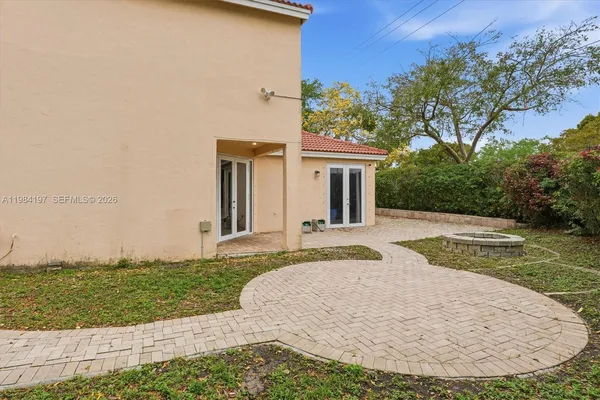 a view of a house with backyard and trees