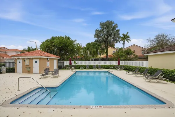 a view of a house with pool fire pit and chairs