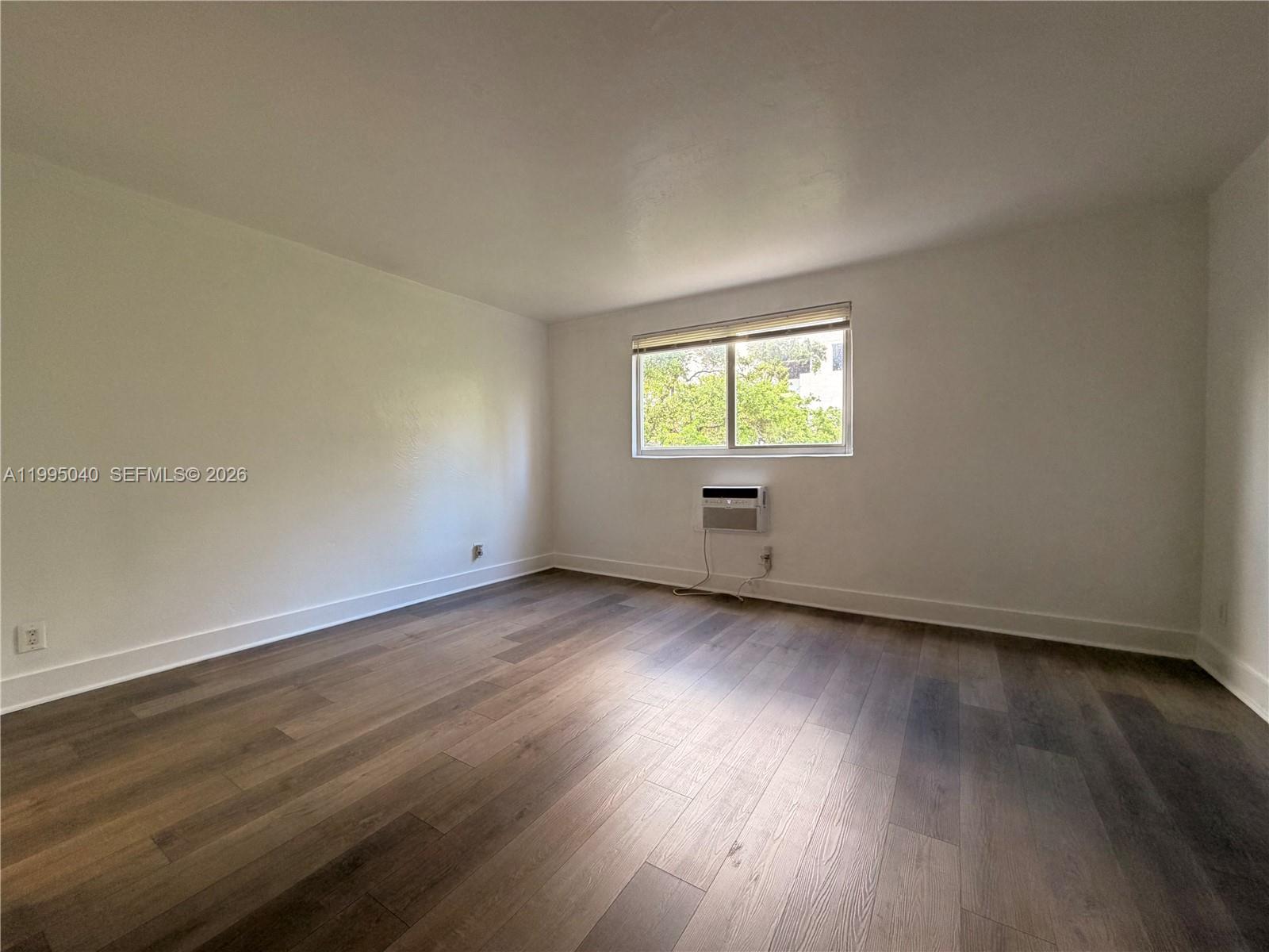 143 Southwest 9th Street, Unit 310 Miami, FL 33130 - Photo 8 of 20 an empty room with wooden floor and windows