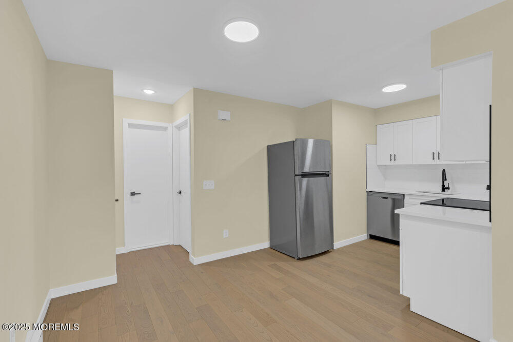 114 3rd Avenue, Unit 8 Belmar, NJ 07719 - Photo 11 of 13 a kitchen with stainless steel appliances a refrigerator and a stove top oven