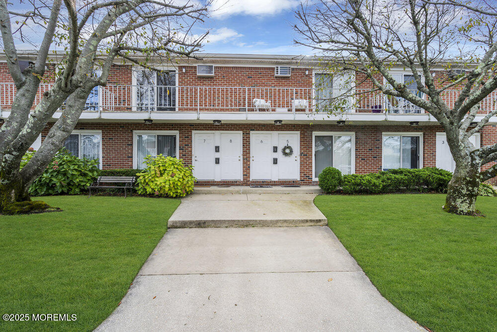 114 3rd Avenue, Unit 8 Belmar, NJ 07719 - Photo 2 of 13 a front view of a house with a garden