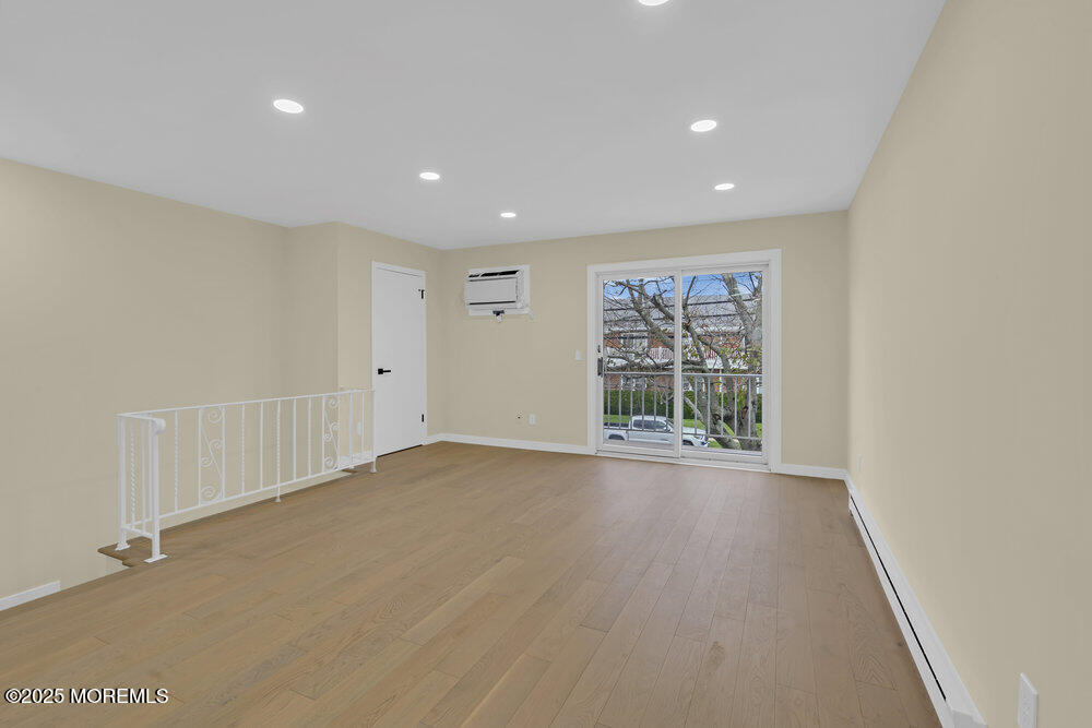 114 3rd Avenue, Unit 8 Belmar, NJ 07719 - Photo 8 of 13 a view of an empty room with wooden floor and a window