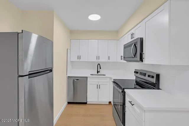 a kitchen with stainless steel appliances a refrigerator sink and cabinets