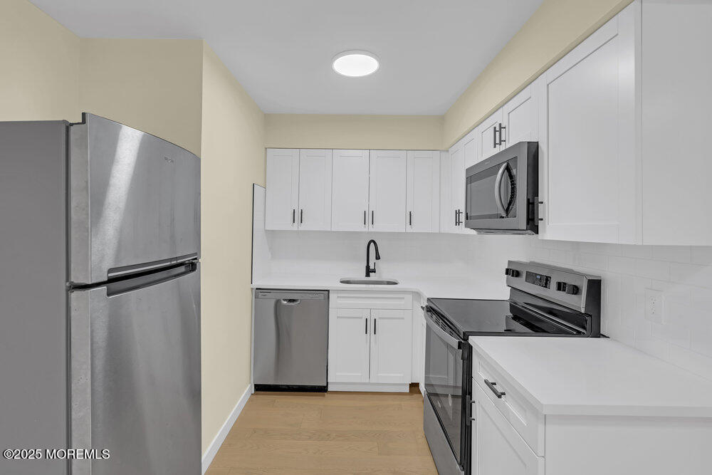 114 3rd Avenue, Unit 8 Belmar, NJ 07719 - Photo 9 of 13 a kitchen with stainless steel appliances a refrigerator sink and cabinets
