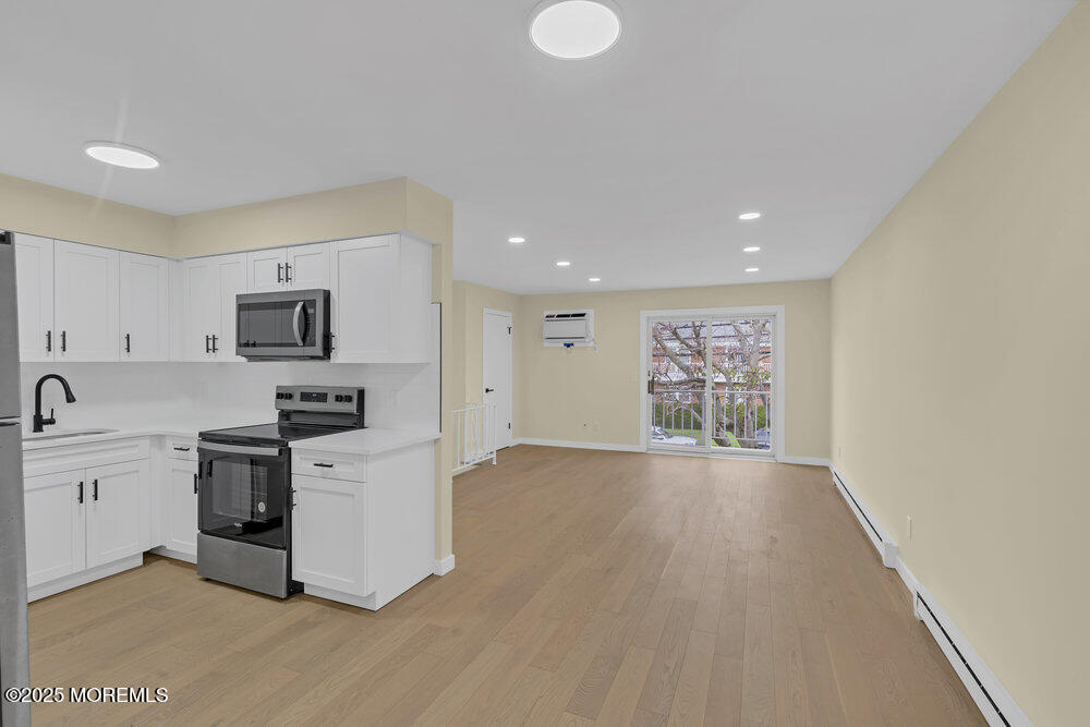 114 3rd Avenue, Unit 8 Belmar, NJ 07719 - Photo 10 of 13 a view of kitchen with stainless steel appliances granite countertop a stove top oven a sink dishwasher and a refrigerator with wooden floor