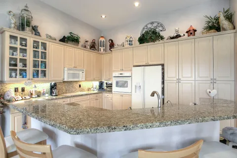 a kitchen with stainless steel appliances granite countertop a sink refrigerator and cabinets