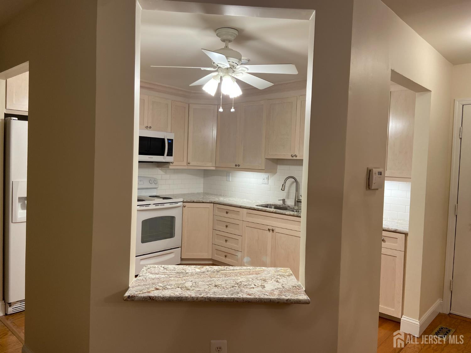 8 Benjamin Franklin Drive, Unit C Monroe Township, NJ 08831 - Photo 2 of 9 a kitchen with stainless steel appliances granite countertop a sink a stove and a refrigerator