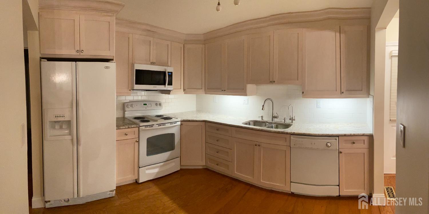 8 Benjamin Franklin Drive, Unit C Monroe Township, NJ 08831 - Photo 3 of 9 a kitchen with stainless steel appliances granite countertop white cabinets a sink a stove a refrigerator and white cabinets