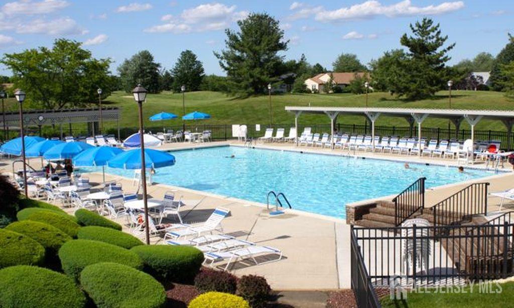 8 Benjamin Franklin Drive, Unit C Monroe Township, NJ 08831 - Photo 8 of 9 a view of a lake with a patio table and chairs