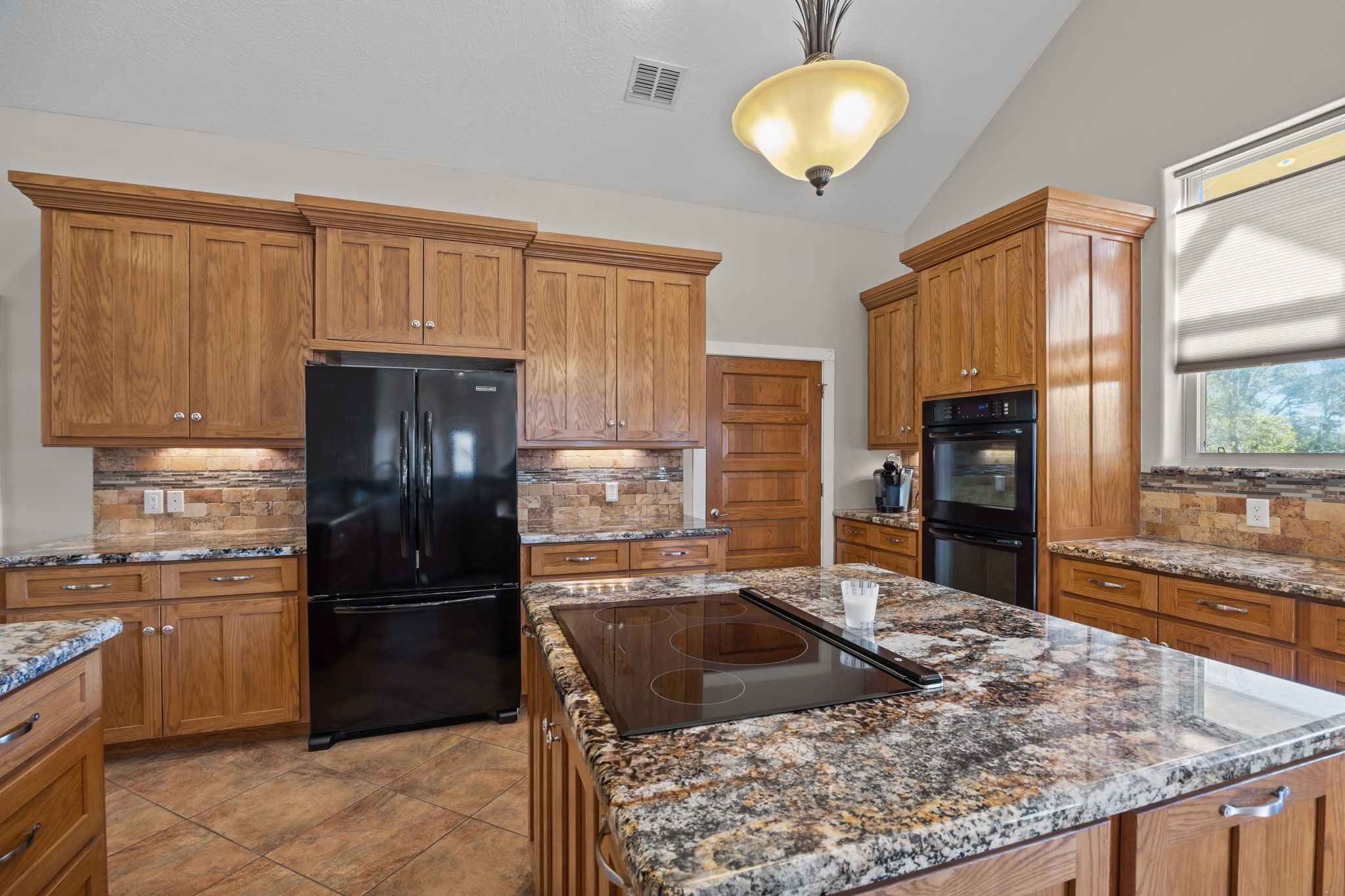3998 County Road 612 Angleton, TX 77515 - Photo 17 of 47 a kitchen with stainless steel appliances granite countertop a refrigerator a stove and a sink with wooden cabinets
