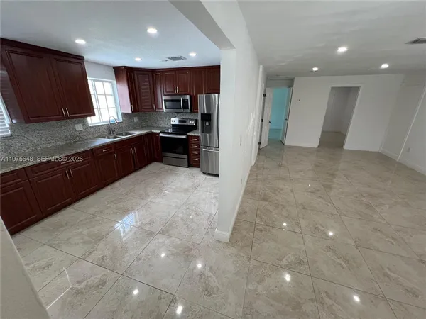 a large kitchen with a large counter top stainless steel appliances and cabinets