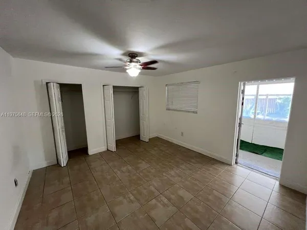 an empty room with fan and windows