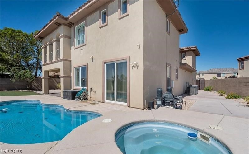 3 Tall Ruff Drive Las Vegas, NV 89148 - Photo 8 of 54 An inviting backyard oasis awaits with a sparkling pool and spa alongside a stucco-finished residence.