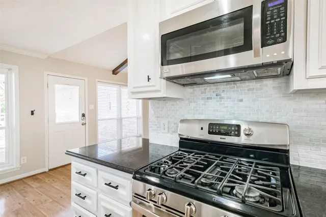 a kitchen with granite countertop a stove and a microwave