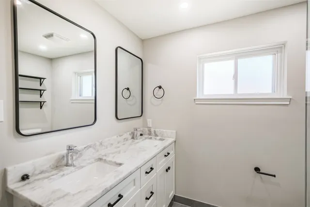 a bathroom with a sink vanity and mirror