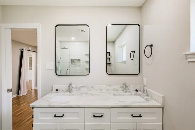 a bathroom with double vanity sinks and a mirror