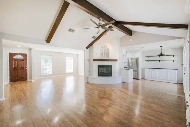 a view of empty room with wooden floor and fireplace
