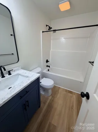 a bathroom with a granite countertop sink toilet a shower and a mirror