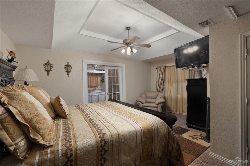 26813 Solis Road La Feria, TX 78559 - Photo 13 of 33 a bedroom with a bed and a chandelier
