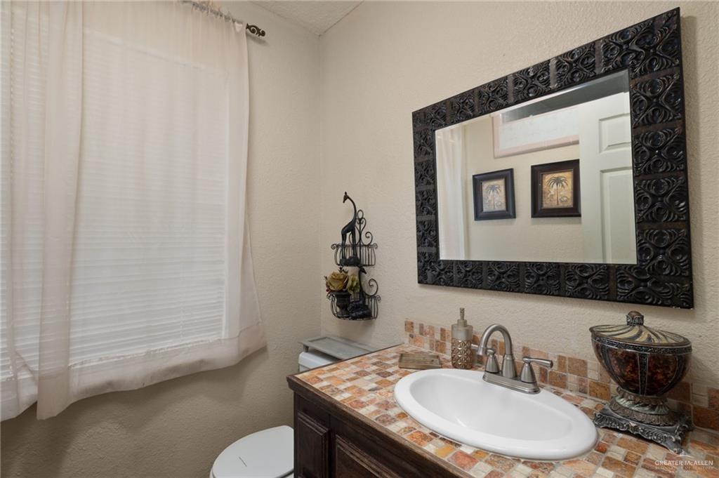 26813 Solis Road La Feria, TX 78559 - Photo 6 of 33 a bathroom with a granite countertop sink and a mirror